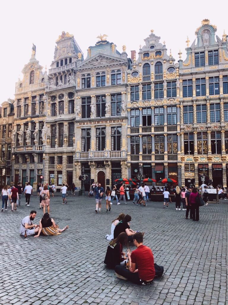 people sitting and standing beside high buildings during daytime
